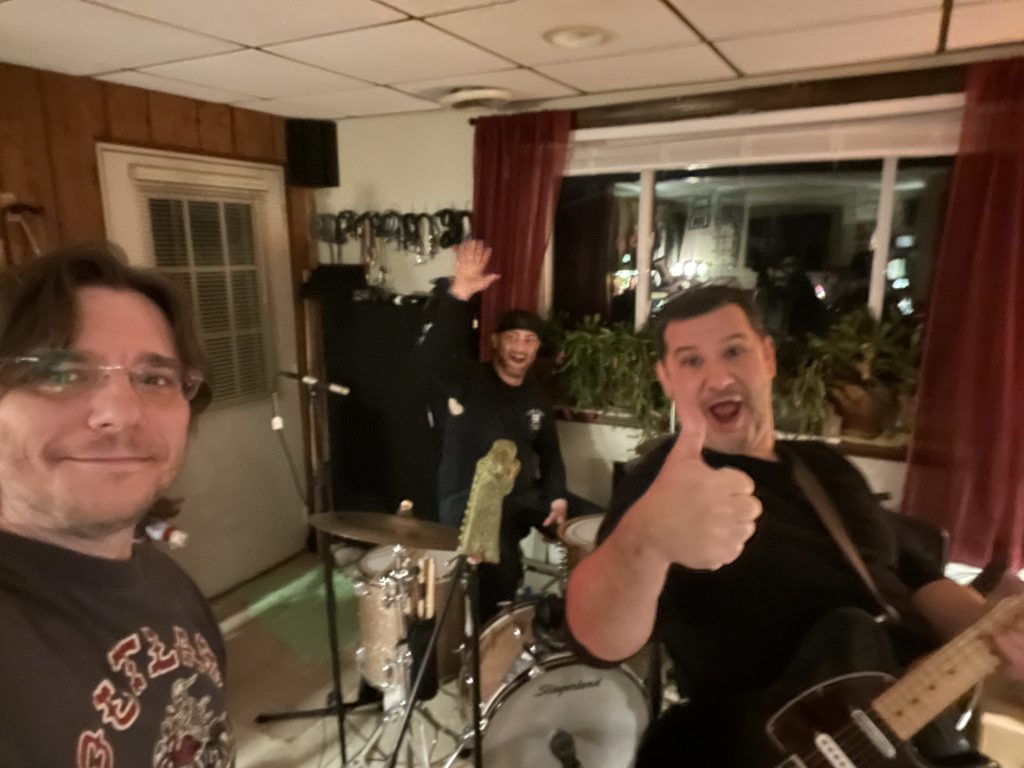 3 friends playing music and one giving a thumbs up