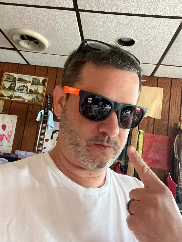 The author poiniting to himslef becasue after 30 years of playing guitar he still can't shred